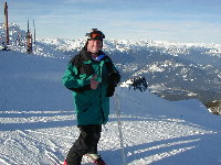 Doug, with Alta Lake in the background, standing on the top of Seventh Heaven at Blackcomb